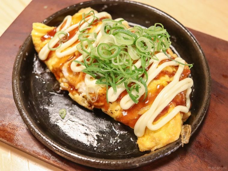 鉄板に盛り付けられたとり平焼きが木製のテーブルの上に置かれている