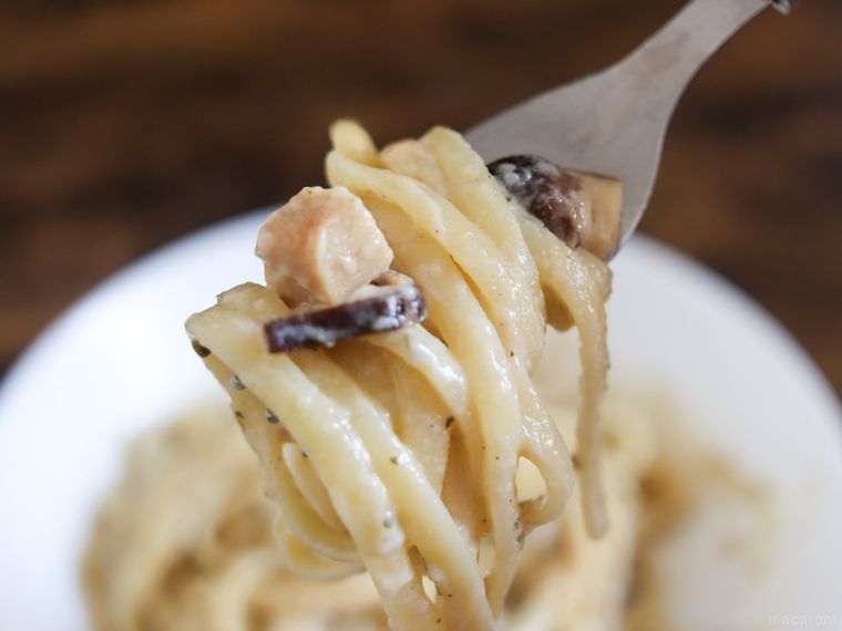 フォークに巻いたきのこクリームパスタのパスタを持ち上げている様子