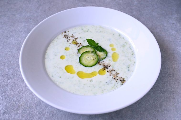 白い丸皿に盛り付けられたきゅうりとヨーグルトの冷製スープ