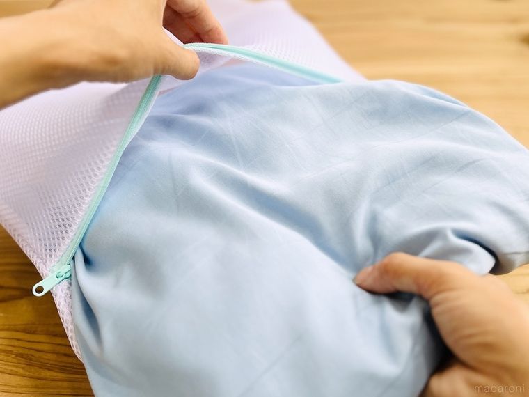 シーツを洗濯ネットに入れている様子