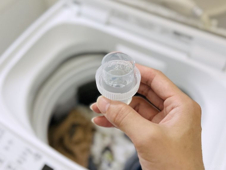 洗濯機に洗剤を入れようとしている様子