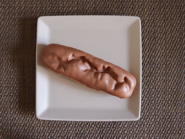 ランチョンマットの上に、モンテールのルマンド風エクレアがのった白い四角いお皿が置かれている