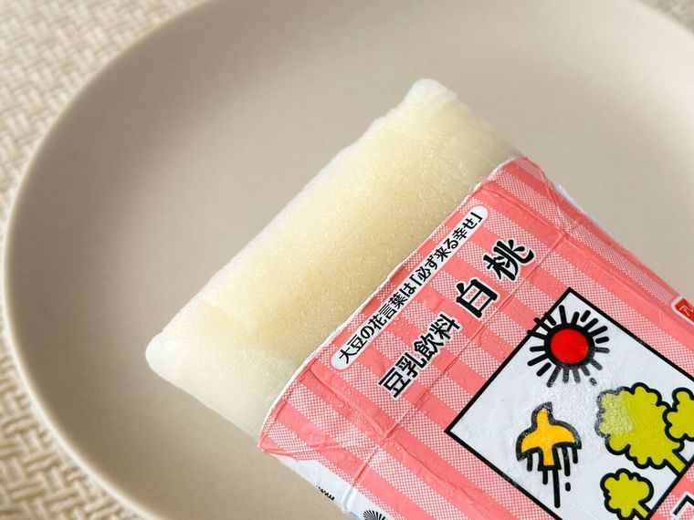 凍った 豆乳飲料 白桃をパッケージから取り出している様子