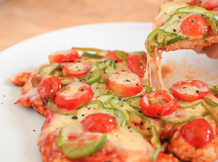 手で持ち上げた鶏むね肉ピザ