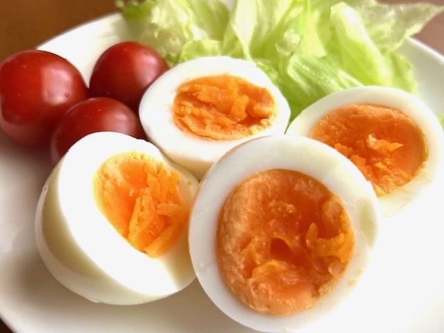 皿に並べられているゆで卵、プチトマト、レタス