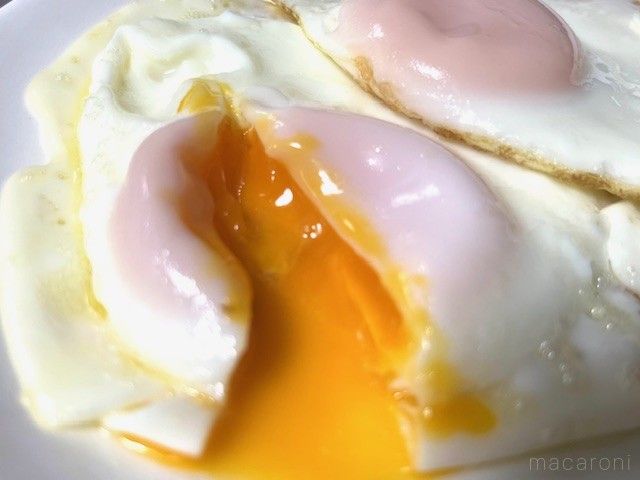 半熟の目玉焼きからきれいな黄身が流れている