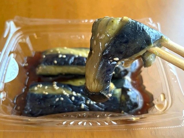 揚げなすの惣菜を箸で食べようとしてる