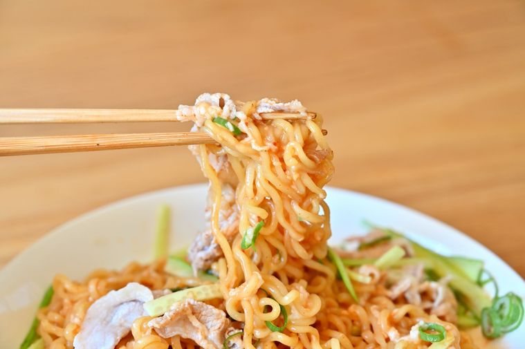 混ぜた冷やし辛ラーメンを箸で持ち上げている