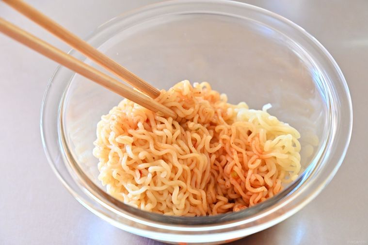 麺を赤い調味料にあえている