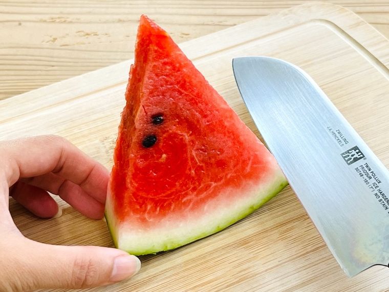 スイカの皮を包丁で取ろうとしている様子