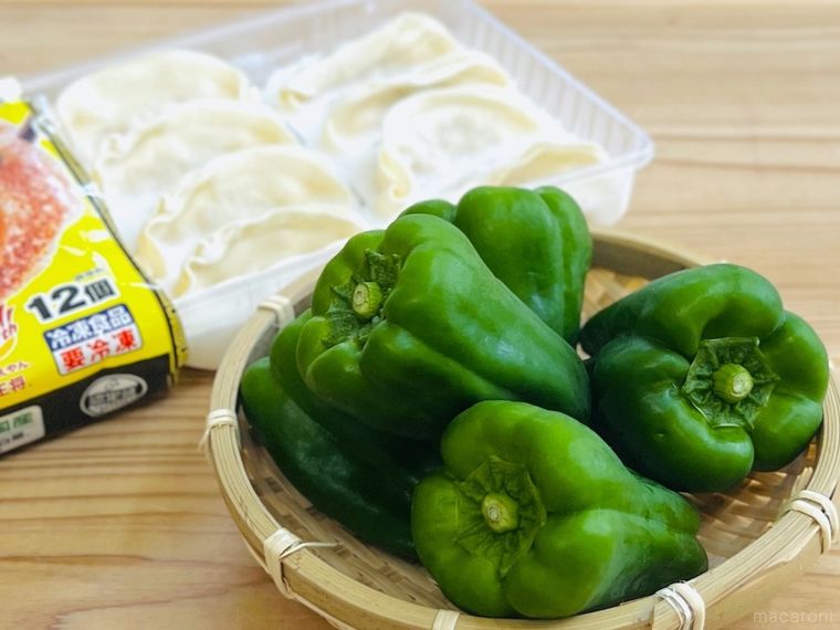 テーブルの上に冷凍餃子とピーマンが置かれている様子