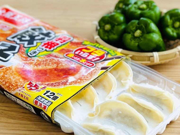 テーブルの上に冷凍餃子とピーマンが置かれている様子