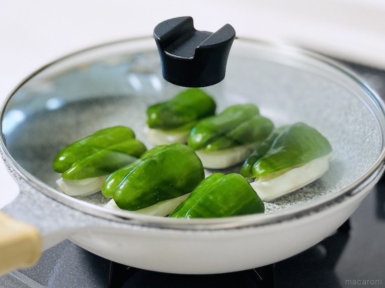 ピーマンをかぶせた冷凍餃子を焼いている様子