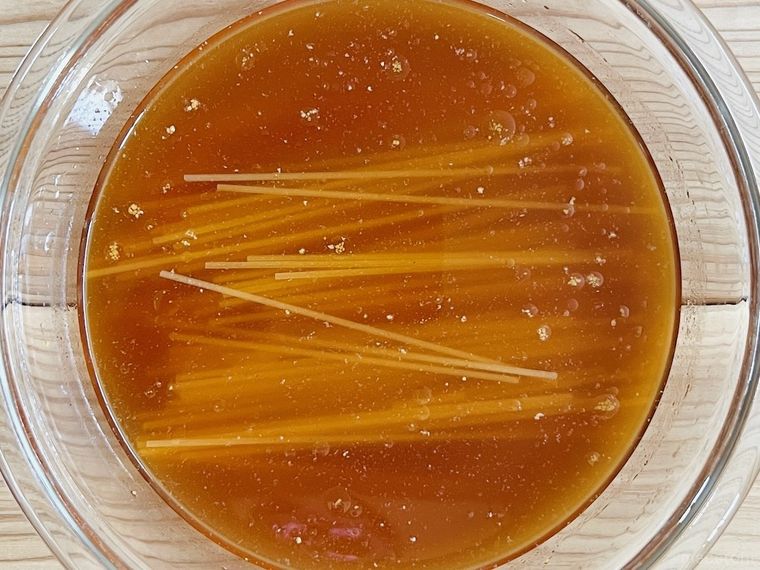 耐熱容器に調味料、水、パスタを入れた様子