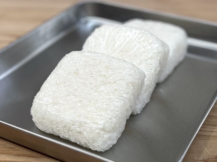 金属トレーの上に、ラップで包んだごはんが3個並んでいる様子