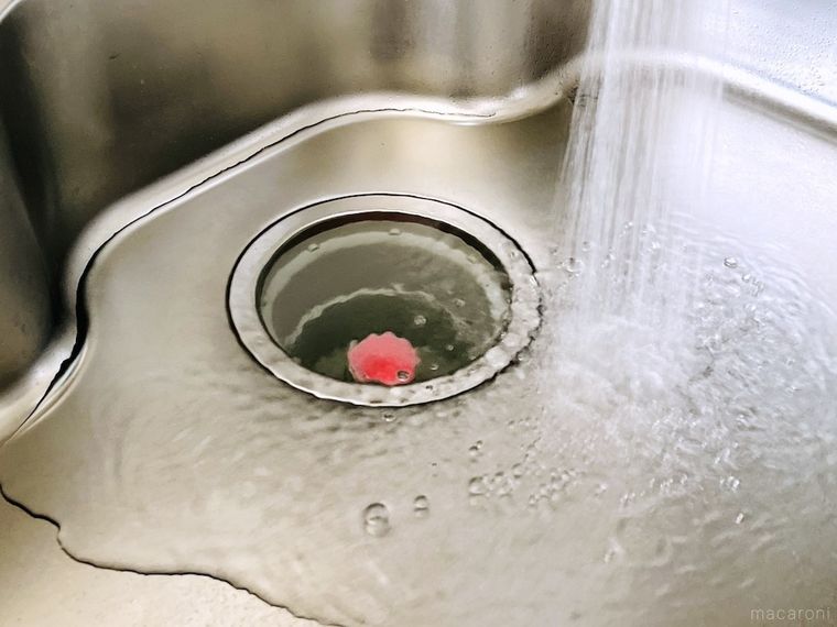 キッチンハイターのキャップを排水口にはめて、シンクに水を溜めている様子