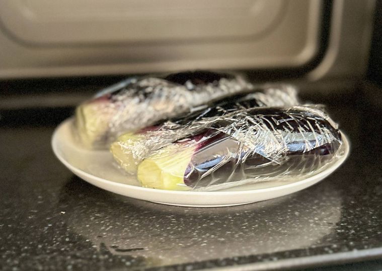 耐熱皿にのったラップに包まれたなす