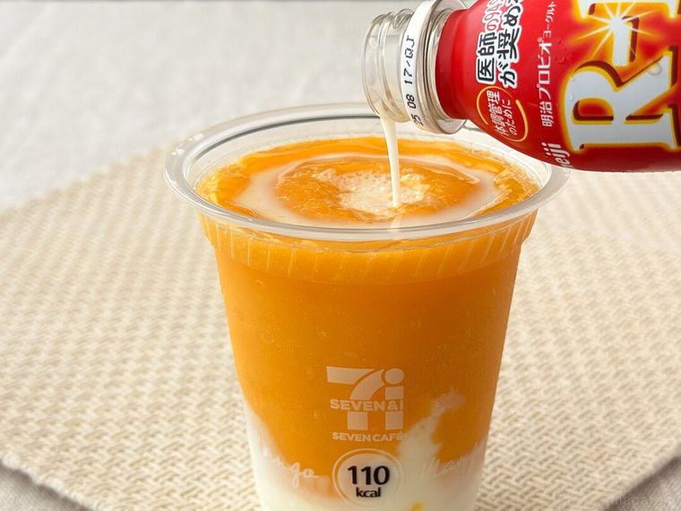 マンゴーマンゴースムージーに明治プロビオヨーグルトR1ドリンクタイプを注いでいる様子