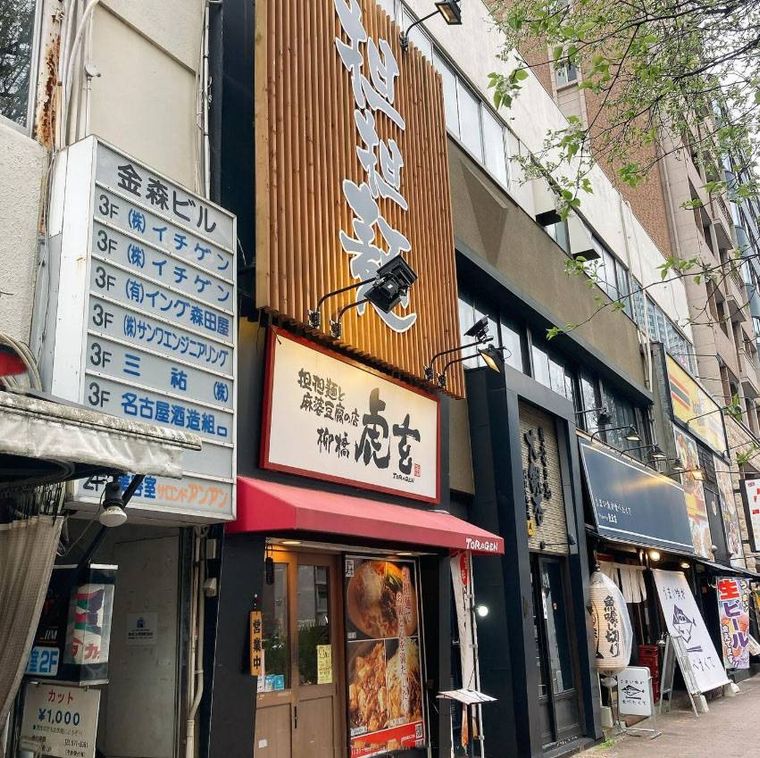 ウッド調の大きな看板と白い看板が掲げられた担担麺と麻婆豆腐の店 柳橋虎玄の外観