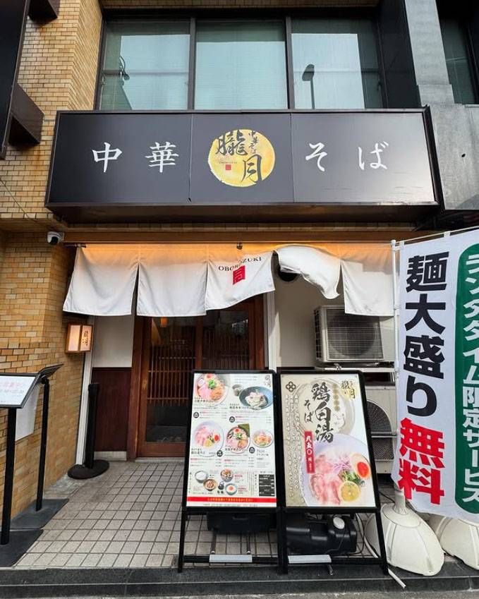 黒い看板と白いのれんがかけられた中華そば 朧月の外観