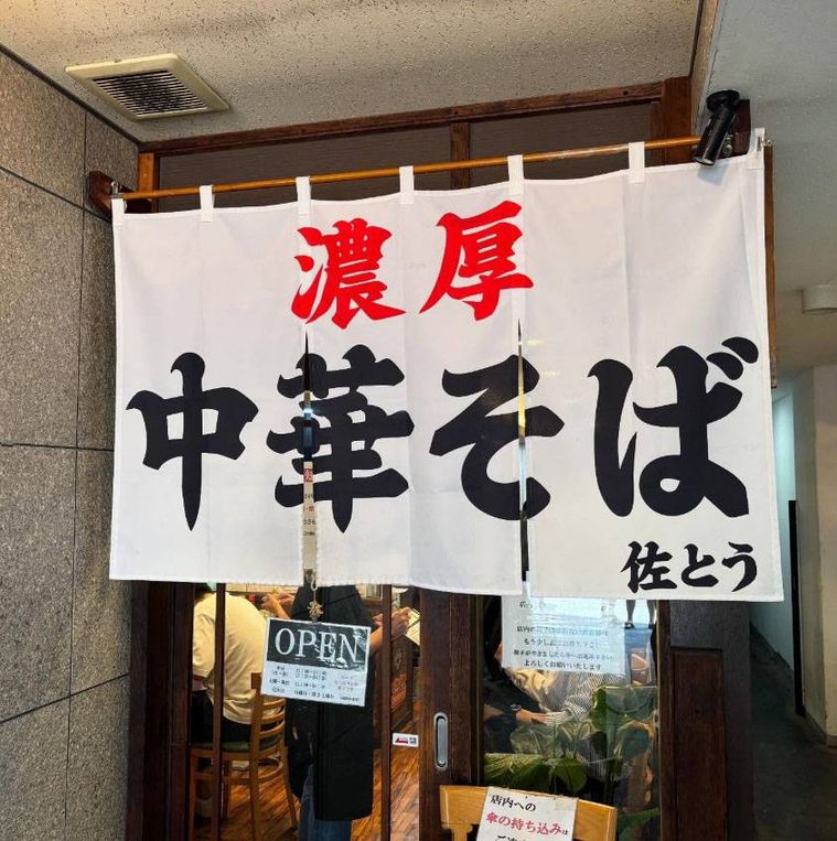 白い店名入りののれんがかかった濃厚中華そば 佐とうの外観