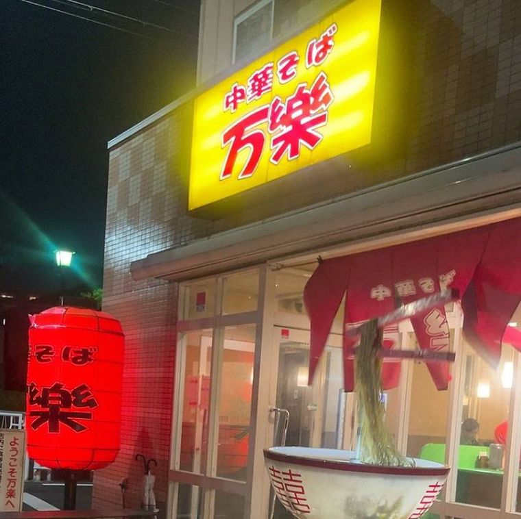 黄色い看板と赤い提灯がかかった中華そば 万楽の外観