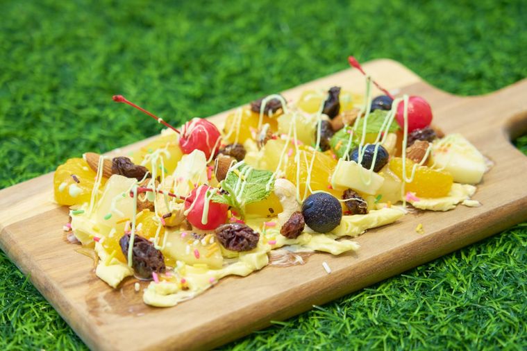 カッティングボードにフルーツやバターが盛られている