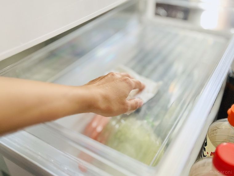 冷蔵庫の野菜室をキッチンペーパーで拭いている様子