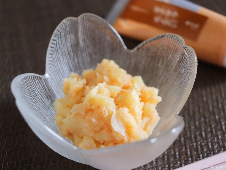 木製のテーブルの上に、久原本家のめんたいチューブシリーズポテサラ めんたいと調理した明太ポテトサラダを並べている