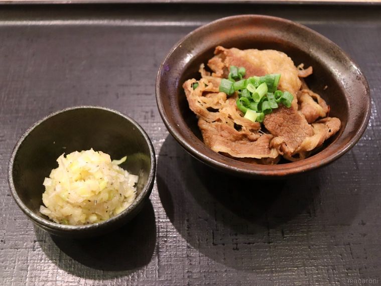 黒い小鉢に盛られた特製ネギ塩ソースと小さなお椀に盛り付けられた牛皿ハーフ