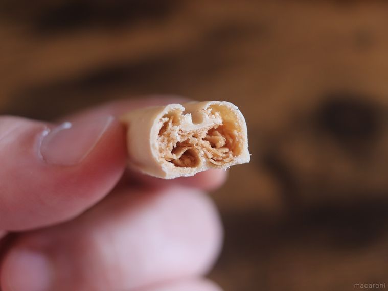 半分に割ったブルボンミニルマンド カスタード風味を手で持っている