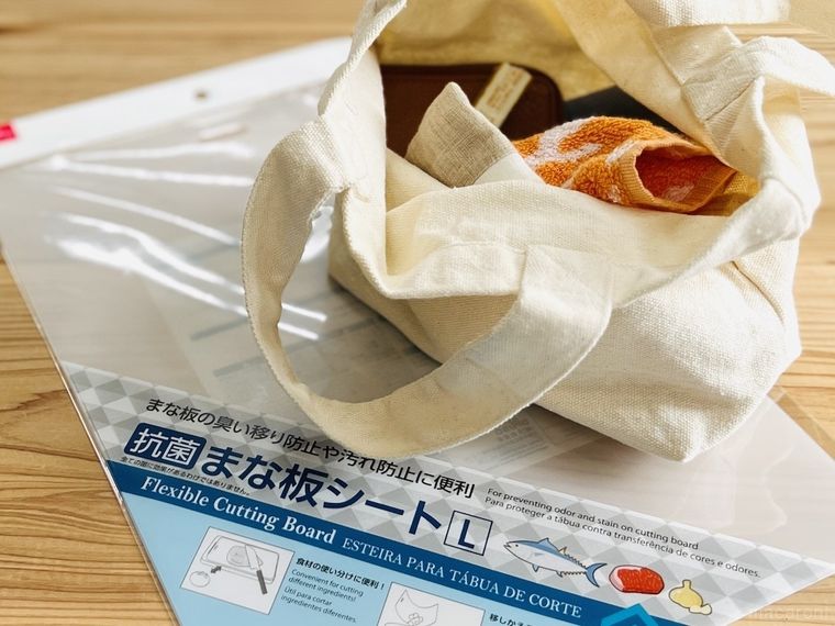 ダイソーの抗菌まな板シートと、荷物が入ったトートバッグ