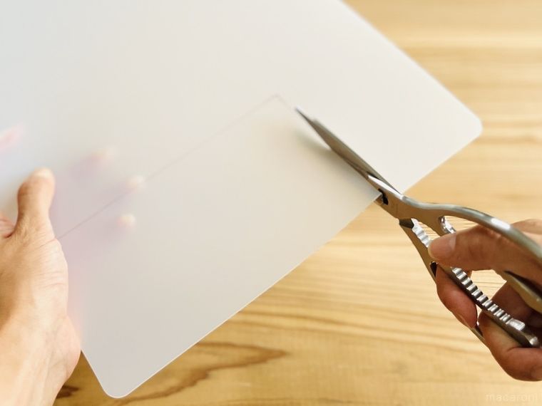 ダイソーの抗菌まな板シートをハサミで切っている様子