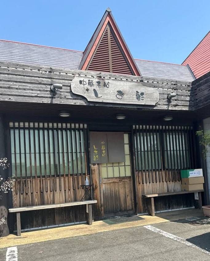 木の外壁と木の看板がかかった中華そば しま彰の外観