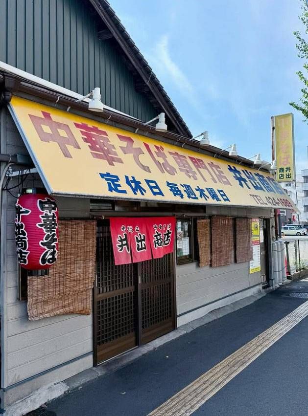 黄色い看板と赤いのれんがかかった和歌山中華そば 井出商店の外観