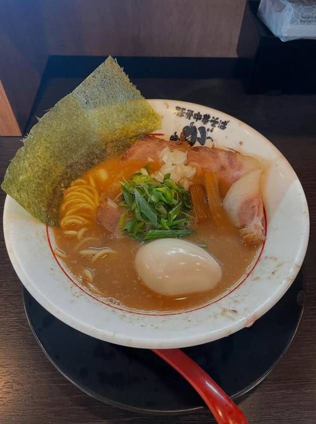 店名入りの白い丼に入った豚骨中華そば玉子入り