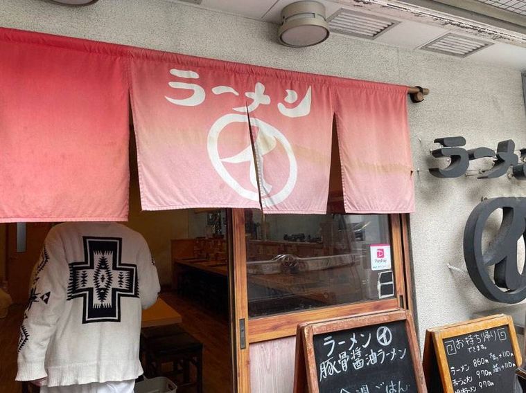 入り口に赤いのれんがかかったまるイ 十二番丁店の外観