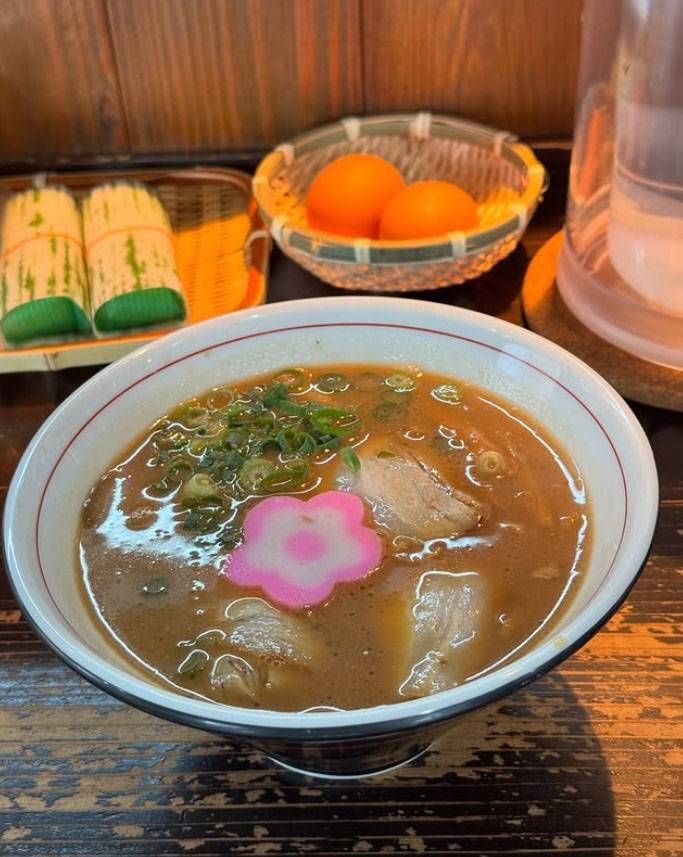 赤いライン入りの白い丼に入った中華そばと寿司ゆで卵