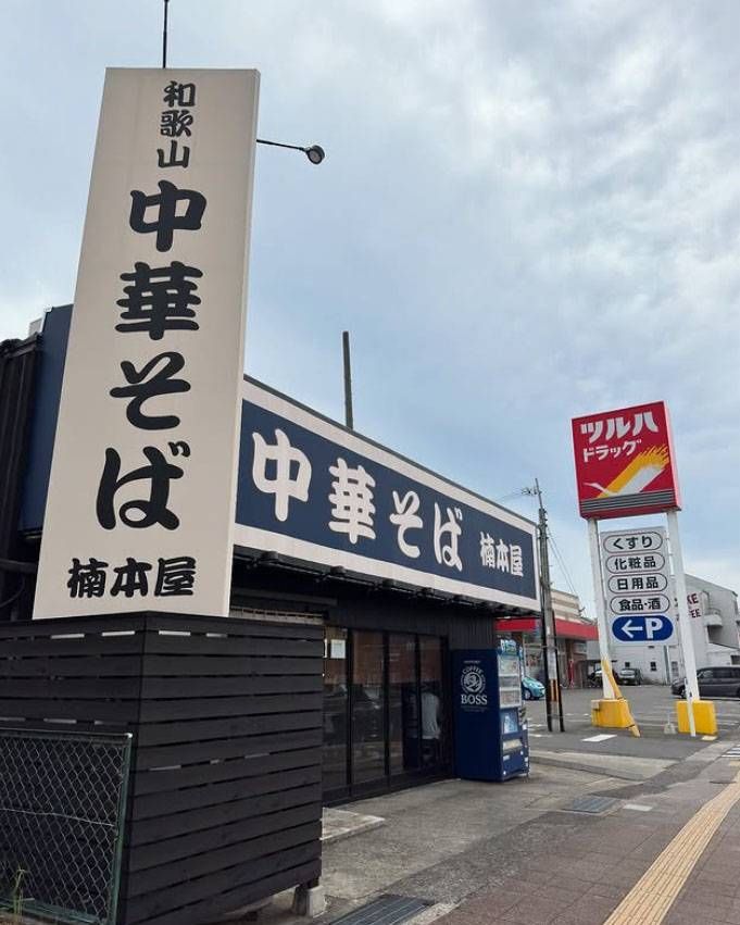 白と紺色の看板がかかった中華そば 楠本屋の外観