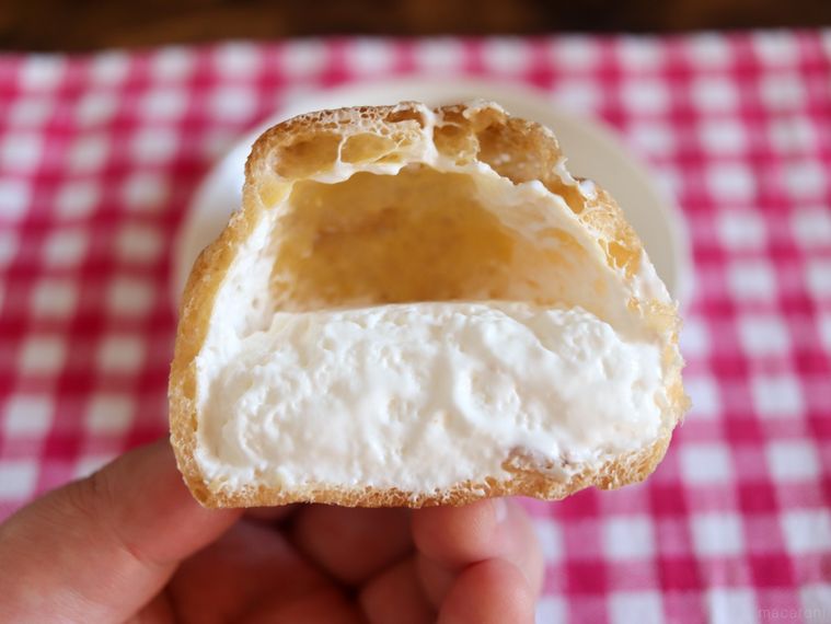 半分に割ったモンテールむちゃうまヨーグルトシュークリームを手で持っている