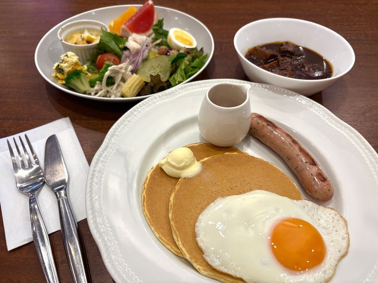目玉焼きとソーセージが添えれたロイヤルホスト特製パンケーキ