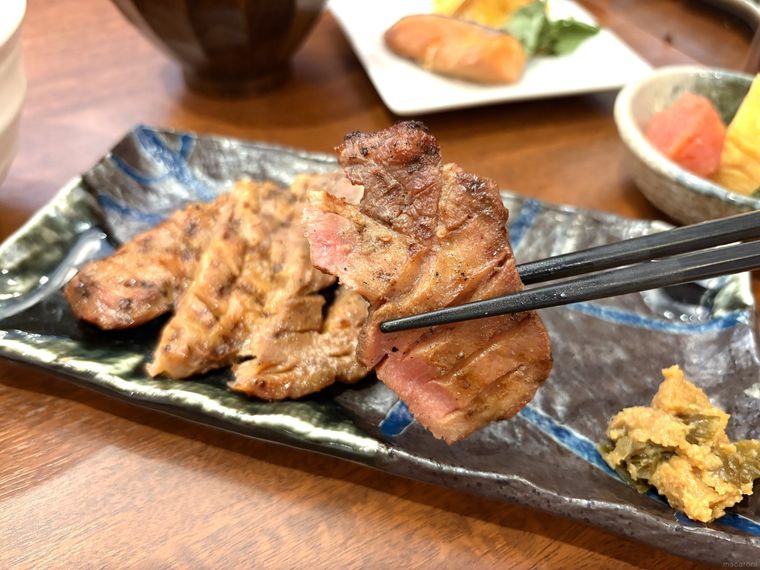 牛たんを箸で持ち上げて食べている様子