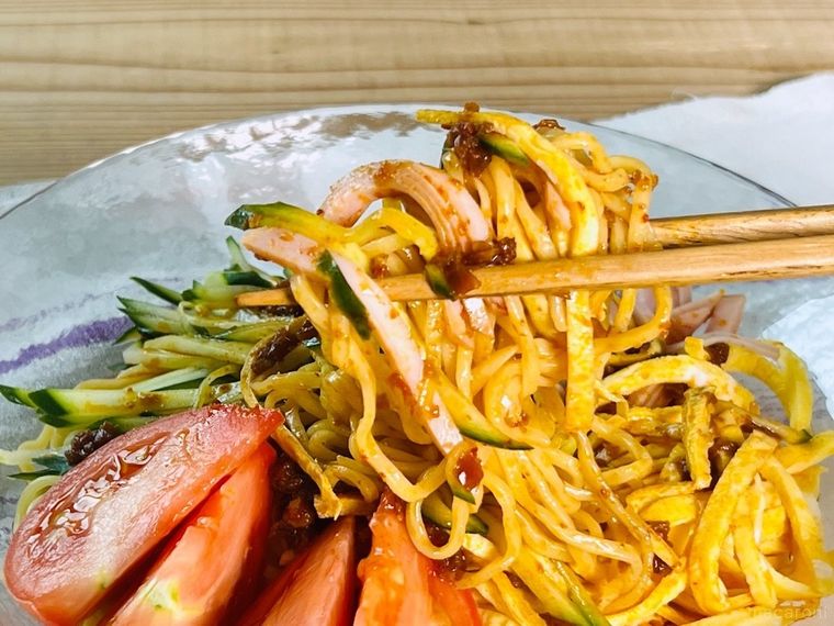 食べる麻辣醤がかかった冷やし中華を箸で持ち上げている様子