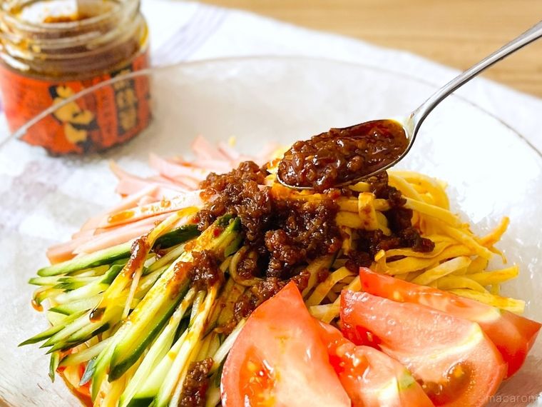 冷やし中華の上に食べる麻辣醤をのせている様子