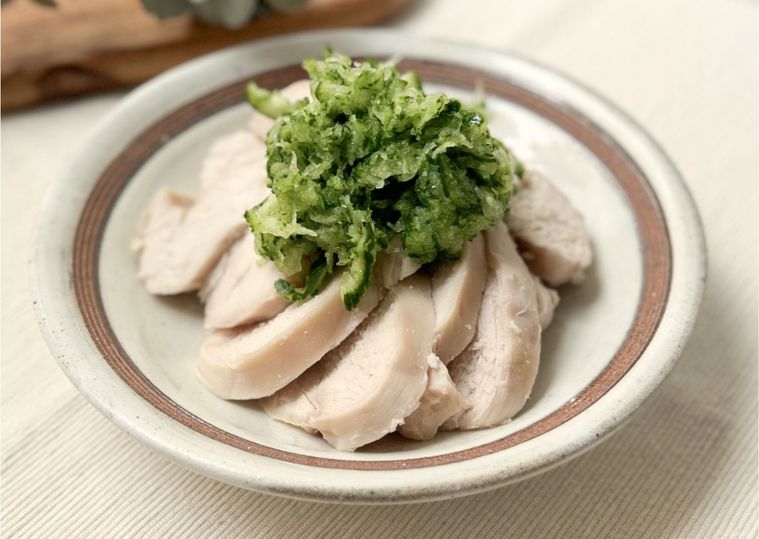 茶色のラインが入った白い皿に盛り付けられた鶏ハムとすりおろしきゅうり