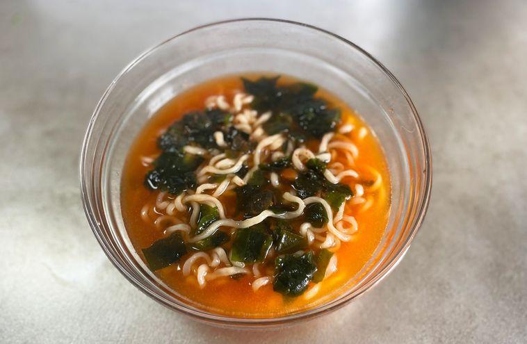 ガラスの器に入れた冷たいラーメンとスープ