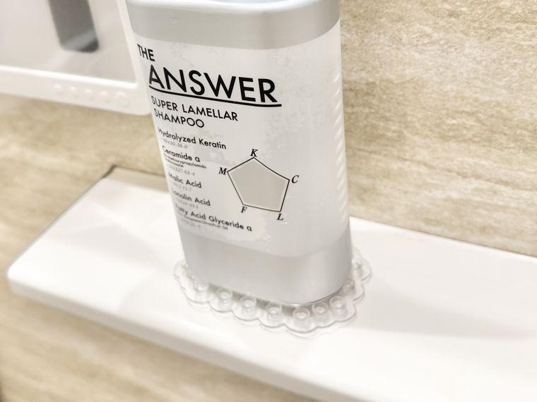 ピタッと吸い付く吸着シートの上に置いたシャンプーボトル