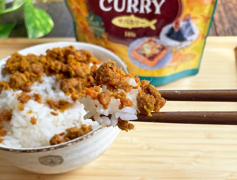 サバカリーを振りかけたご飯を箸でつかんでいる写真