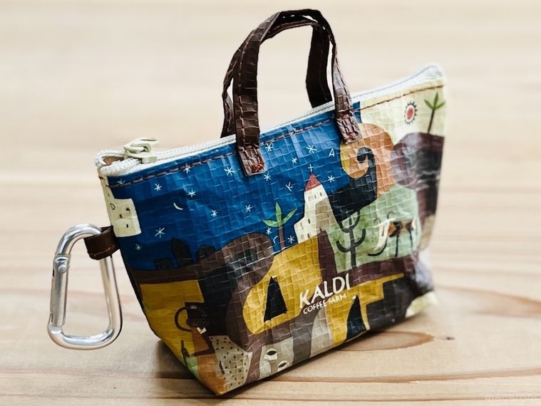 テーブルに置かれたカルディ伝説柄カラビナ付きミニバッグ