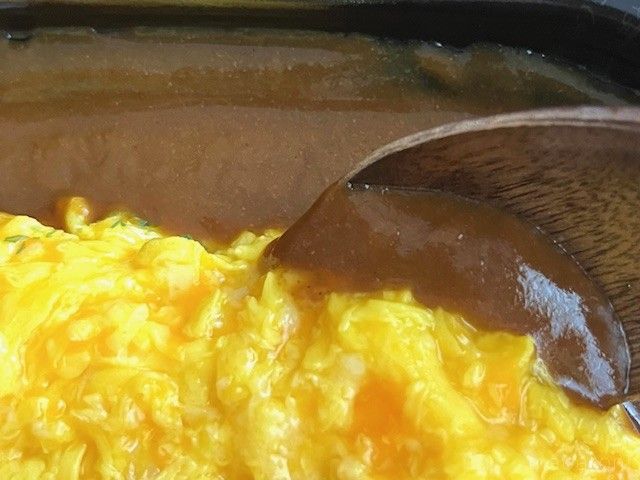 さらっとしたカレーをスプーンですくっている